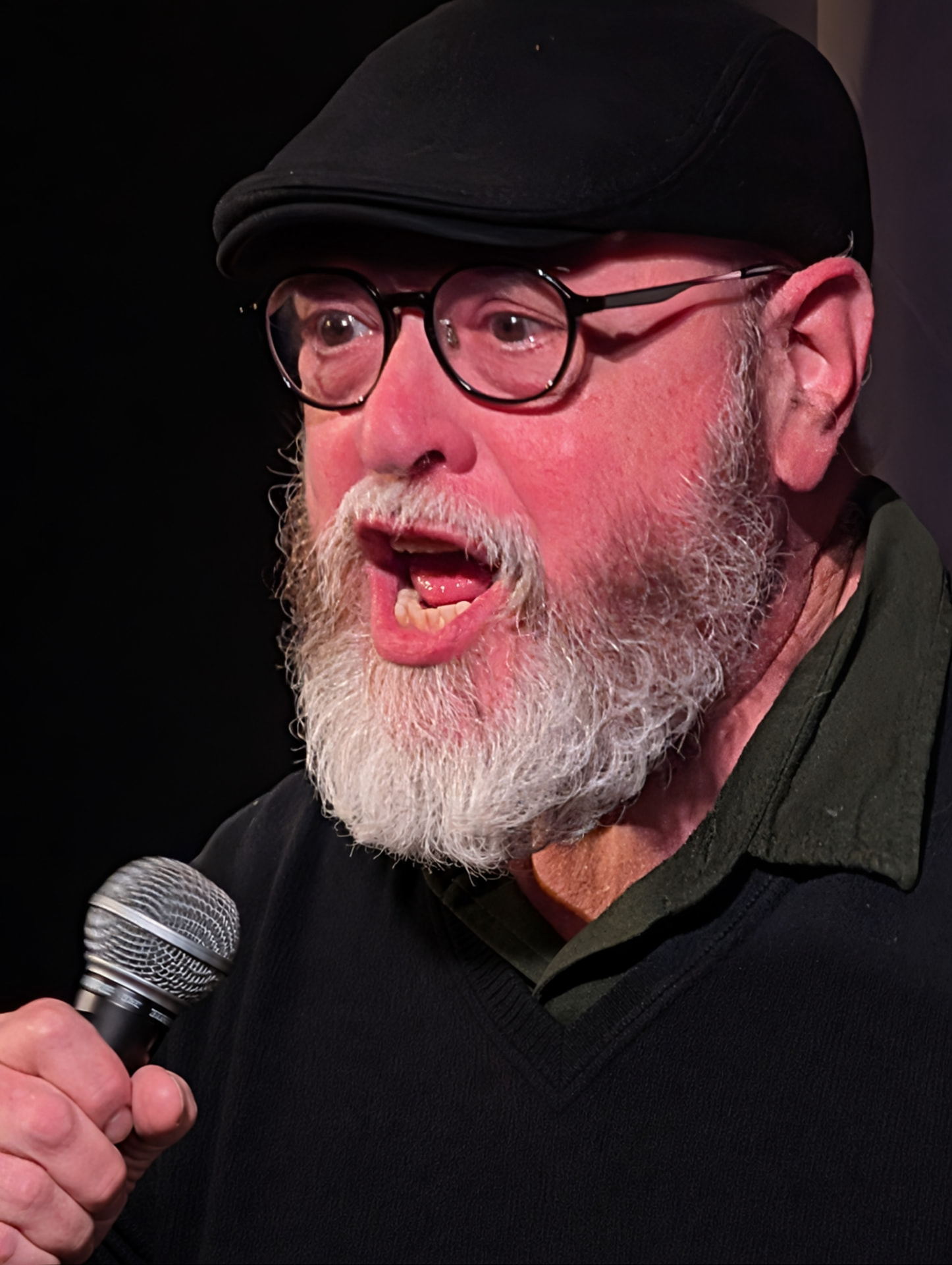 Dr. Jeff Levine holding a microphone, telling a story on stage